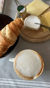 Milchkaffee mit Croissant und Käseplatte