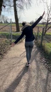 Frau mit Mütze und Jacke im Winter beim Spaziergang